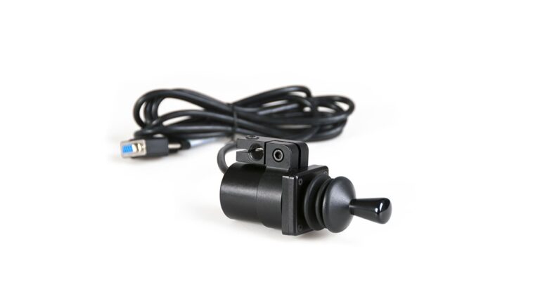 A black USB joystick switch with a slender stick and a coiled cable ending in a USB plug, placed on a white background. Ideal for use as Alternative Access Controls.