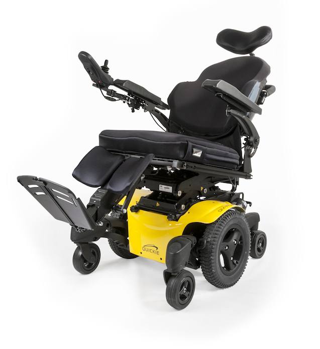 A modern power tilt wheelchair with a yellow base, black cushioned seat, headrest, adjustable armrests, and elevated leg rests. This complex wheelchair features large rear wheels and small front wheels for enhanced mobility.