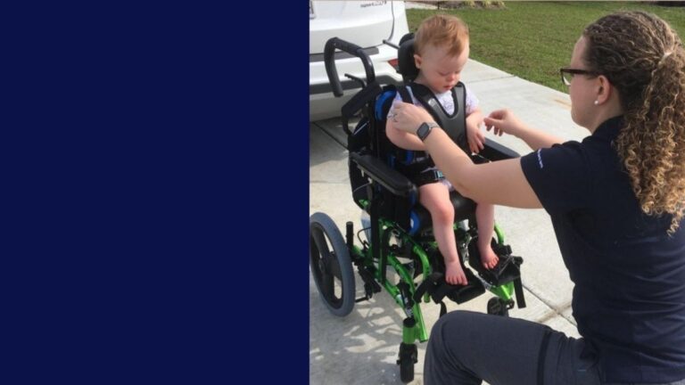A woman kneels in front of a young child seated in a green wheelchair outdoors, adjusting the child’s harness. The scene from Allies Story unfolds on a sunny driveway.