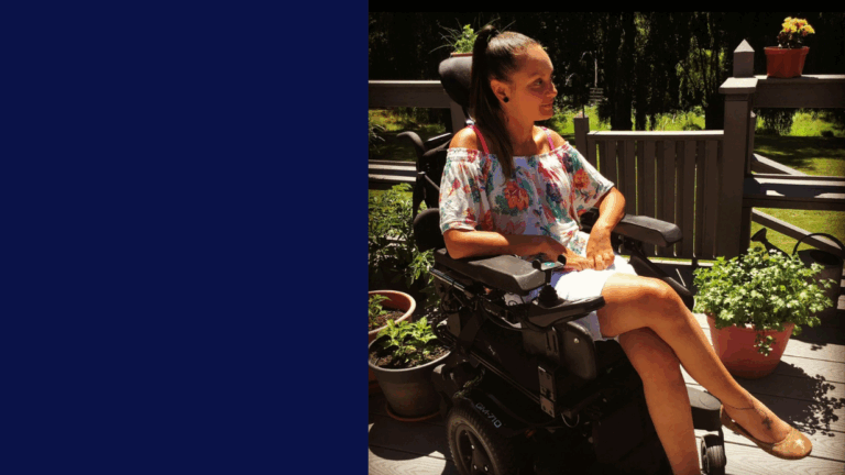 Morgans Story: A woman in a floral top and white skirt sits in a power wheelchair on a sunny patio, surrounded by potted plants and greenery. She looks to the side and smiles.
