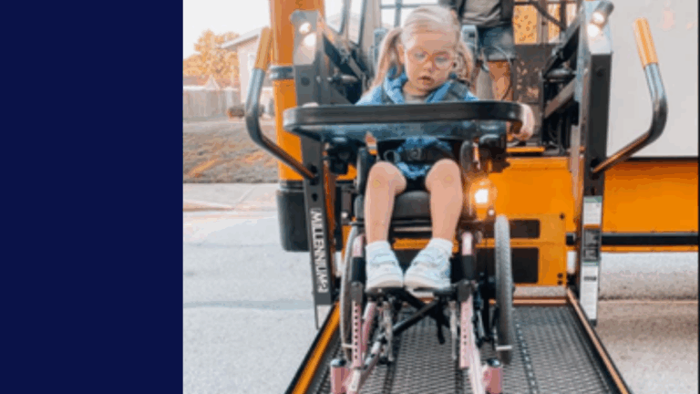 Evelyn’s Story: A young girl in a wheelchair is being lifted onto a school bus using a wheelchair lift. She wears glasses and sneakers, with the bus and a sunny outdoor background visible.