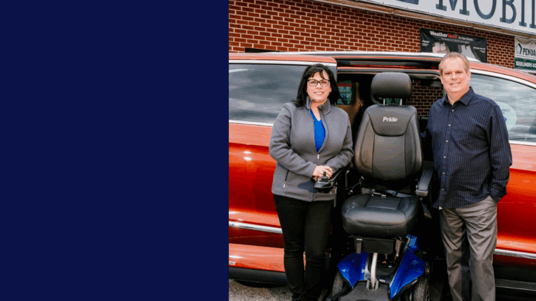 Patti and Michael stand beside a red vehicle with an open door, showing a motorized wheelchair lift. Smiling, they pose for the photo, with the left side of the image filled by a solid navy blue color.