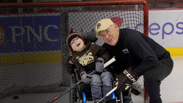 A man and a boy in a wheelchair share a moment together, highlighting Parkers Story.